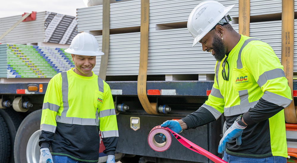 two men in yellow vests working and smiling